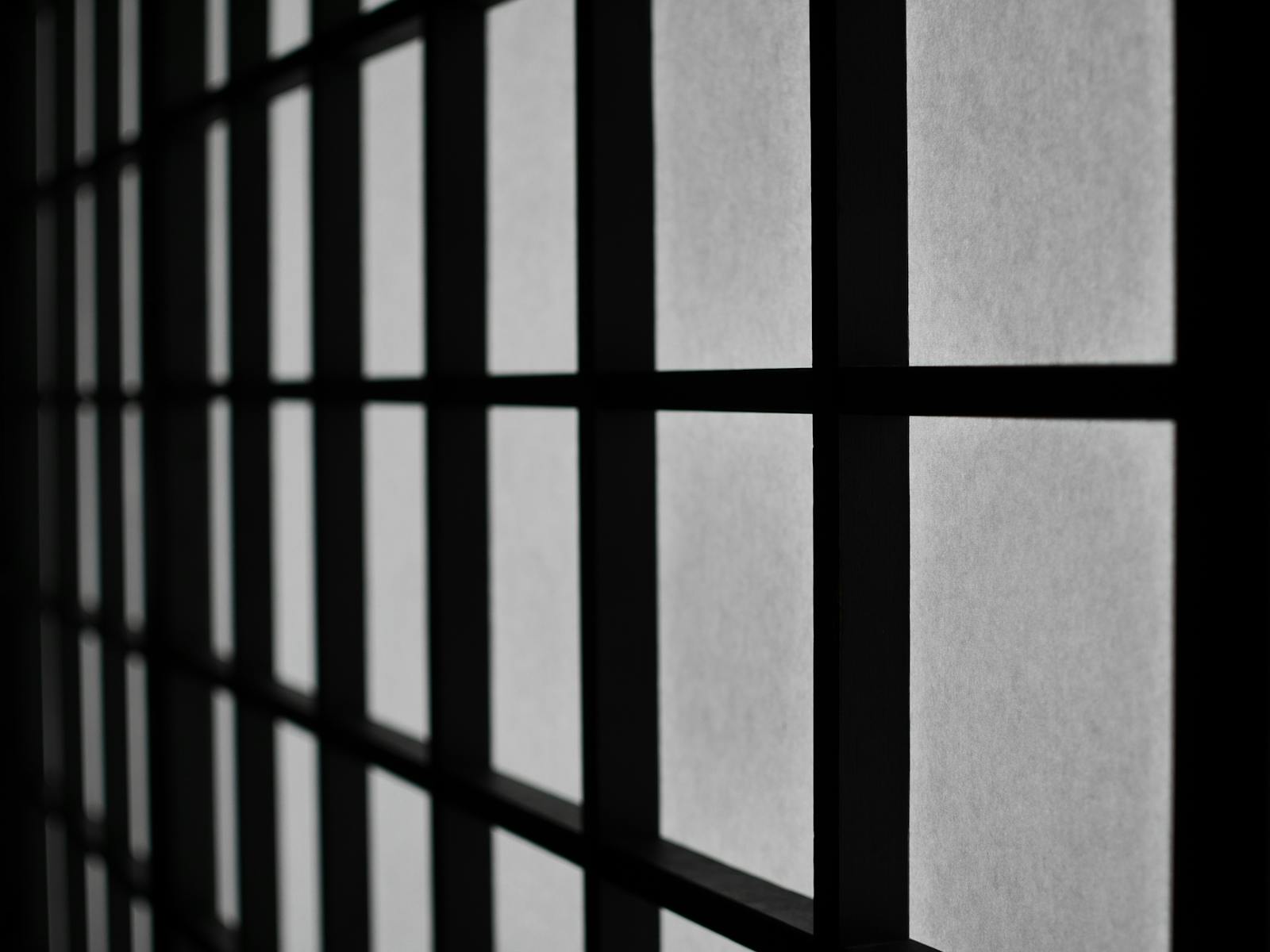 Motif de fenêtre géométrique abstrait noir et blanc créant une atmosphère maussade.