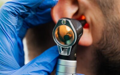 Gros plan d'un médecin utilisant un otoscope pour examiner l'oreille d'un patient.
