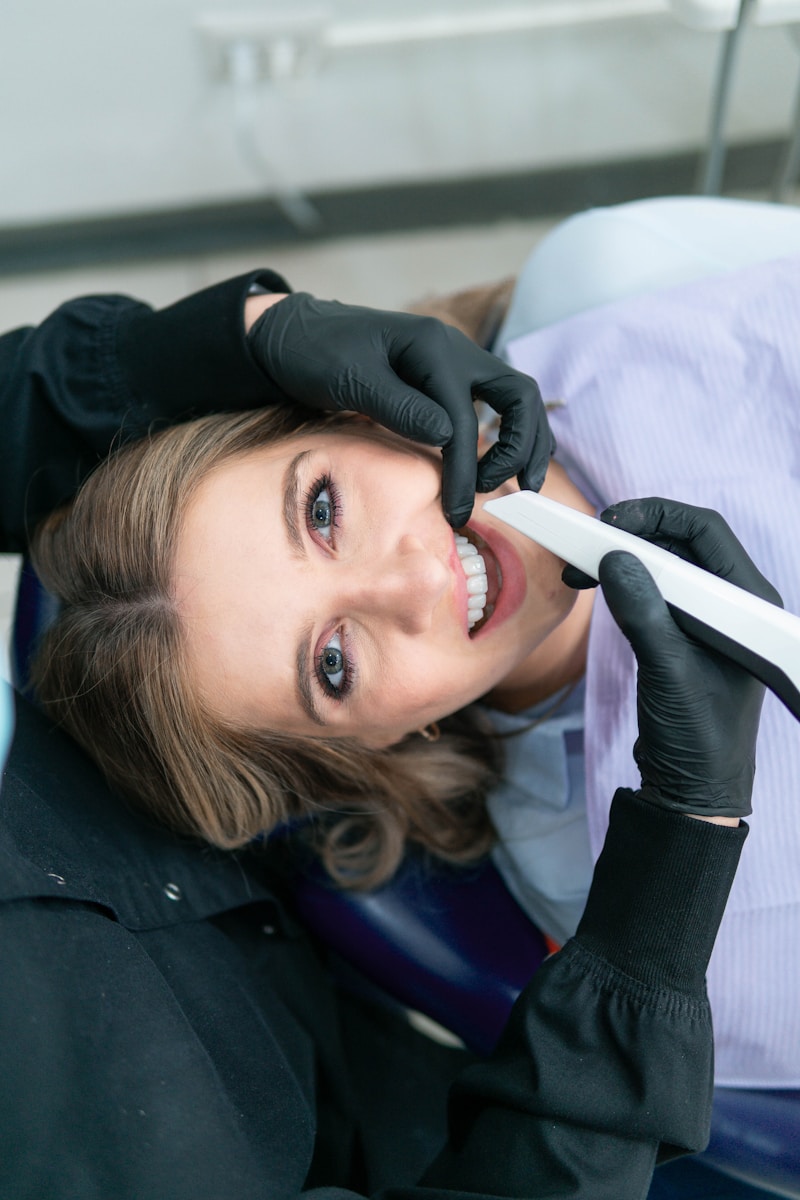 une femme sourit en tenant une brosse à dents